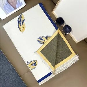 Detailed view of feather pattern scarf with fine white fringes and double-sided texture