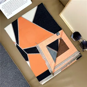 Close-up of geometric color block scarf with soft tassel edges and branded wash label