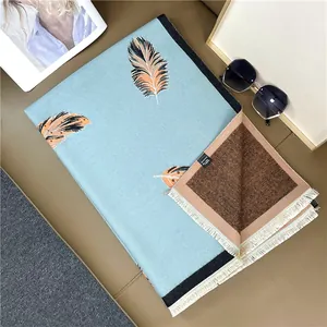 Detail of elegant blue shawl with feather pattern, soft fringe edges and premium texture