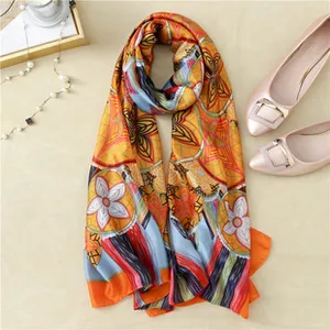 Detailed pattern of printed silk scarf with floral and geometric motifs in bright colors