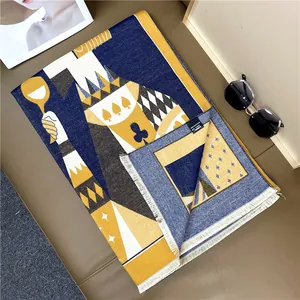 Detail of playing card pattern on double-sided thick scarf with tassels and navy yellow tones