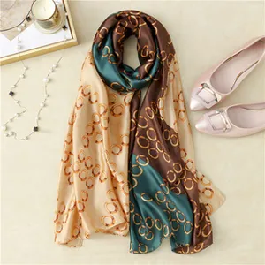 Detailed flat lay of silk scarf with gold ring geometric pattern and elegant accessories