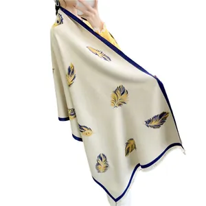Elegant cream winter shawl with blue feather print and decorative fringe tassels