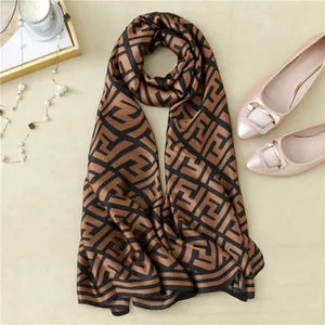 Detail of a brown silk scarf with vintage geometric prints and smooth fabric texture