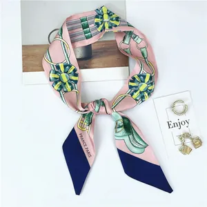 Detailed close-up of pink and navy twilly silk scarf with floral harness patterns