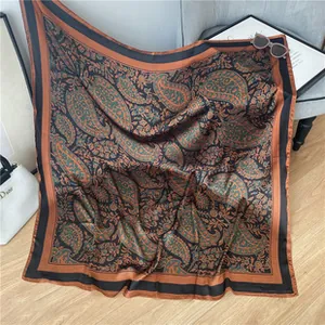 Detail shot of a large satin square scarf with vintage paisley patterns on a chair