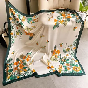 Detail van vintage zijden sjaal met bloemen, vlinders en donkergroene randafwerking
