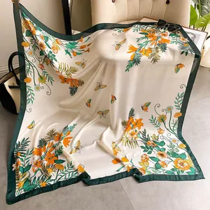 Dettaglio di un foulard in seta con stampe di gigli e farfalle drappeggiato sul divano