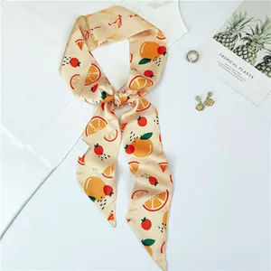 Detailed macro view of beige twilly silk scarf with orange fruit pattern and berries