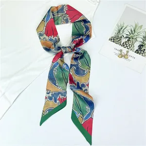 Detail of color-blocked twilly scarf tied in a knot over a white blouse for women