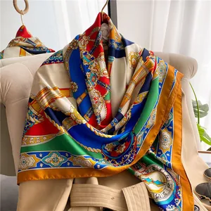 Close-up of royal court print silk scarf with golden chain details on a beige trench coat