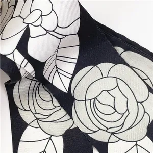 Detalle macro de la textura de sarga y el estampado de camelia en este pañuelo de seda