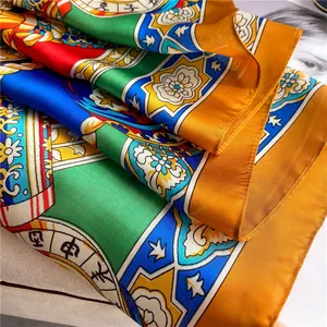 Detail of satin silk scarf featuring vibrant zodiac patterns and floral print texture