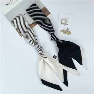 Detail of black and white striped skinny silk scarves for hair or bag decoration