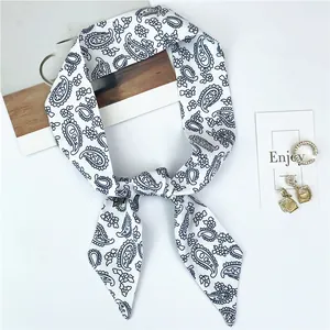 Vue détaillée d'un foulard en soie à motif cachemire avec bijoux et décor minimaliste