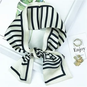 Gros plan du foulard twilly à rayures noires et blanches et motifs géométriques