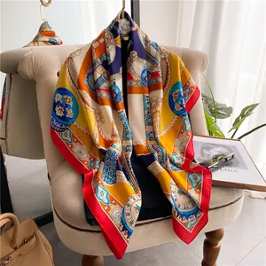 Luxurious satin silk square scarf with colorful geometric compass print on a sofa