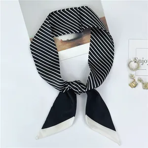 Detail showing elegant black and white striped silk scarf tied as a fashion necktie