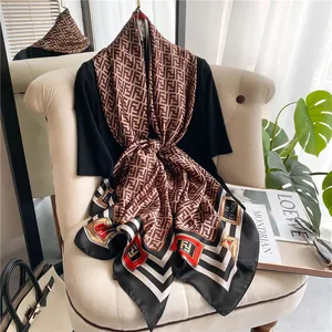 Detailed view of luxury brown silk scarf with FF pattern draped on an armchair