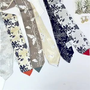 Vue détaillée de divers foulards en soie imprimés fleuris avec bords roulés fins