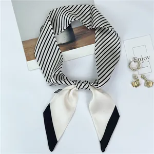 Detail of a chic black and white striped twilly silk scarf styled on a fashion magazine