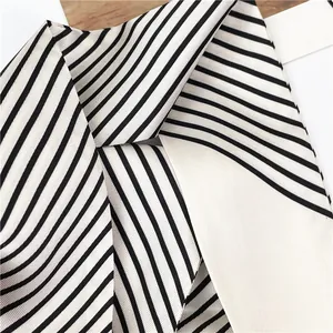 Close-up of black and white striped silk scarf showing twill weave texture and satin finish