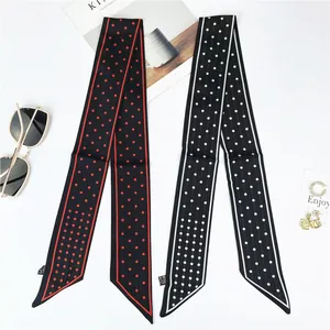 Detail of silk-like neck scarves with red and white polka dot patterns on white background