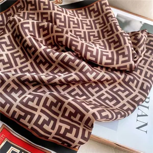 Detail of silk satin scarf showing smooth texture and interlaced letter patterns