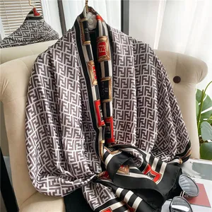 Close-up of lightweight silk-like scarf with vintage pattern draped on a beige sofa