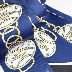 Detail of navy silk scarf featuring a gold chain link pattern and twill texture