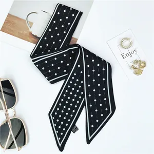 Polka dot silk-like skinny scarf with elegant fashion accessories on white background