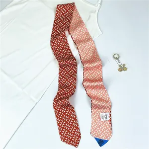 Detail of red and pink geometric silk scarf with intricate triangular patterns and silky finish