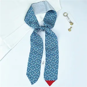 Detailed view of blue geometric pattern faux silk twilly scarf with security tag