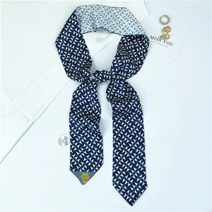 Detail of navy and white geometric silk scarf with 100% polyester care label and accessories