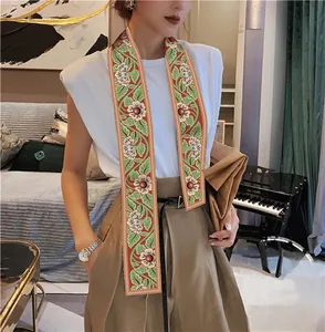 Detailed view of floral printed silk scarf worn as a necktie with modern urban outfit
