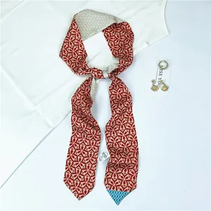 Rust red vintage geometric print silk twilly scarf styled as bow on white silk fabric