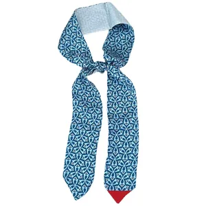 Blue silk-like skinny scarf with geometric floral patterns and pointed red contrast tip