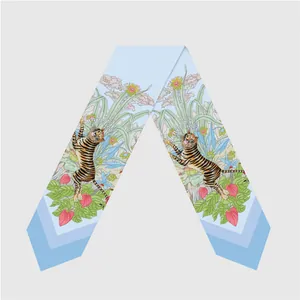 Light blue silk twilly scarf with tiger and floral patterns in a skinny long ribbon style