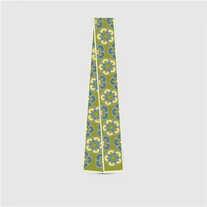 Detail of olive green narrow twilly scarf with floral prints and white piping edges