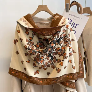 Close-up of thick cashmere-like shawl with orange butterfly and tree patterns