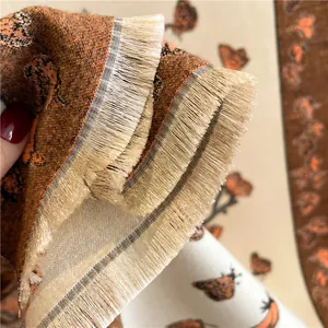 Macro detail of butterfly jacquard pattern and fine tassel fringe on knit shawl