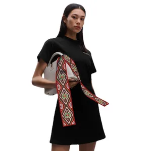 Floral silk twilly scarf tied on a white leather handbag with a stylish geometric pattern
