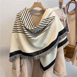 Detail of thick striped cashmere-like scarf with fringe texture and soft knit material
