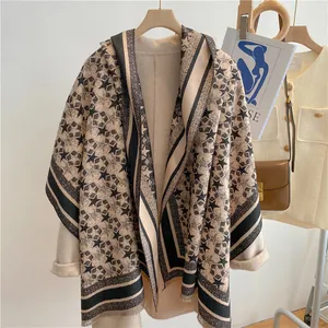 Macro detail of beige winter scarf featuring black star patterns and fringe texture