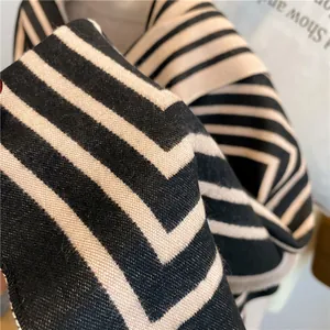 Vue rapprochée de l'écharpe en cachemire noir et beige avec tissage sergé épais et franges