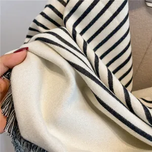 Close-up of soft black and white striped cashmere scarf with elegant fringe detail
