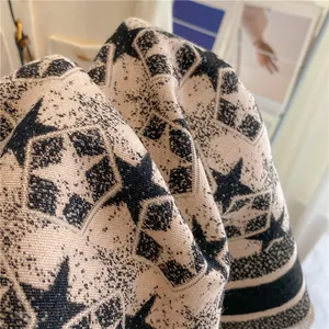 Detail of star pattern knit scarf with thick wool texture and fringe edges
