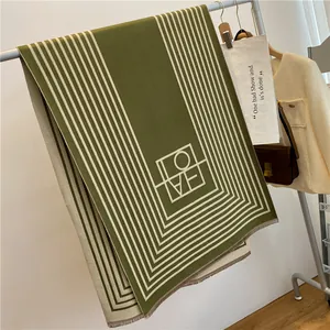 Détail de l'écharpe en cachemire à rayures vert foncé et beige avec lettrage LOVE