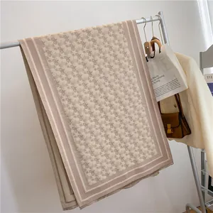 Detailed close-up of pink star pattern cashmere scarf with soft fringes on a hanger