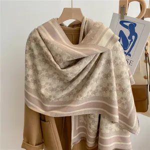 Detail of star pattern and fringe on thick cashmere-like long scarf over wool coat